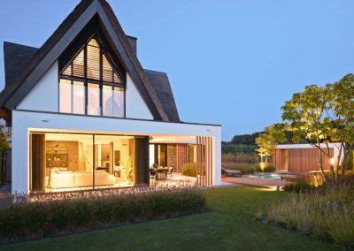 villa met moderne tuin in de avond sparq tuinen